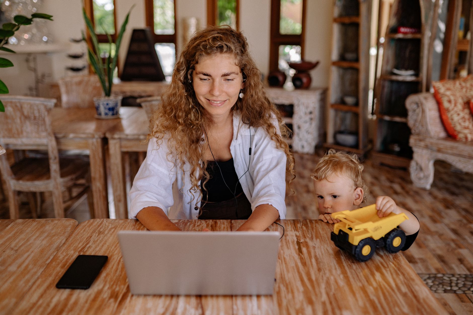 Mamma che lavora come assistente virtuale da casa durante l'estate con i figli