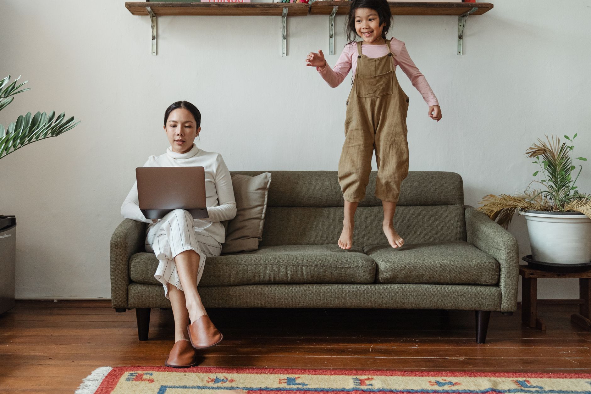 Donna in smart working nel suo home office con vita familiare sullo sfondo